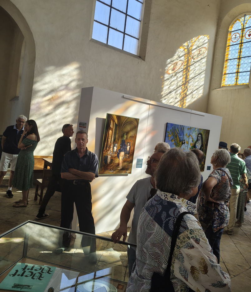 Photographie du vernissage avec les reflets lumineux dans la chapelle